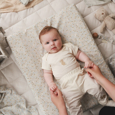 Aerial view of a baby lying on a changing cushion nature trail
