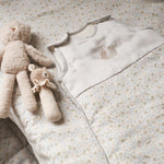Teddies and sleeping ba on cotbed fitted sheet