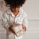 Winter ski pyjamas worn by a boy while holding gifts