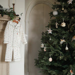 A boys pyjamas in nutrcker hanging next to Christmas tree