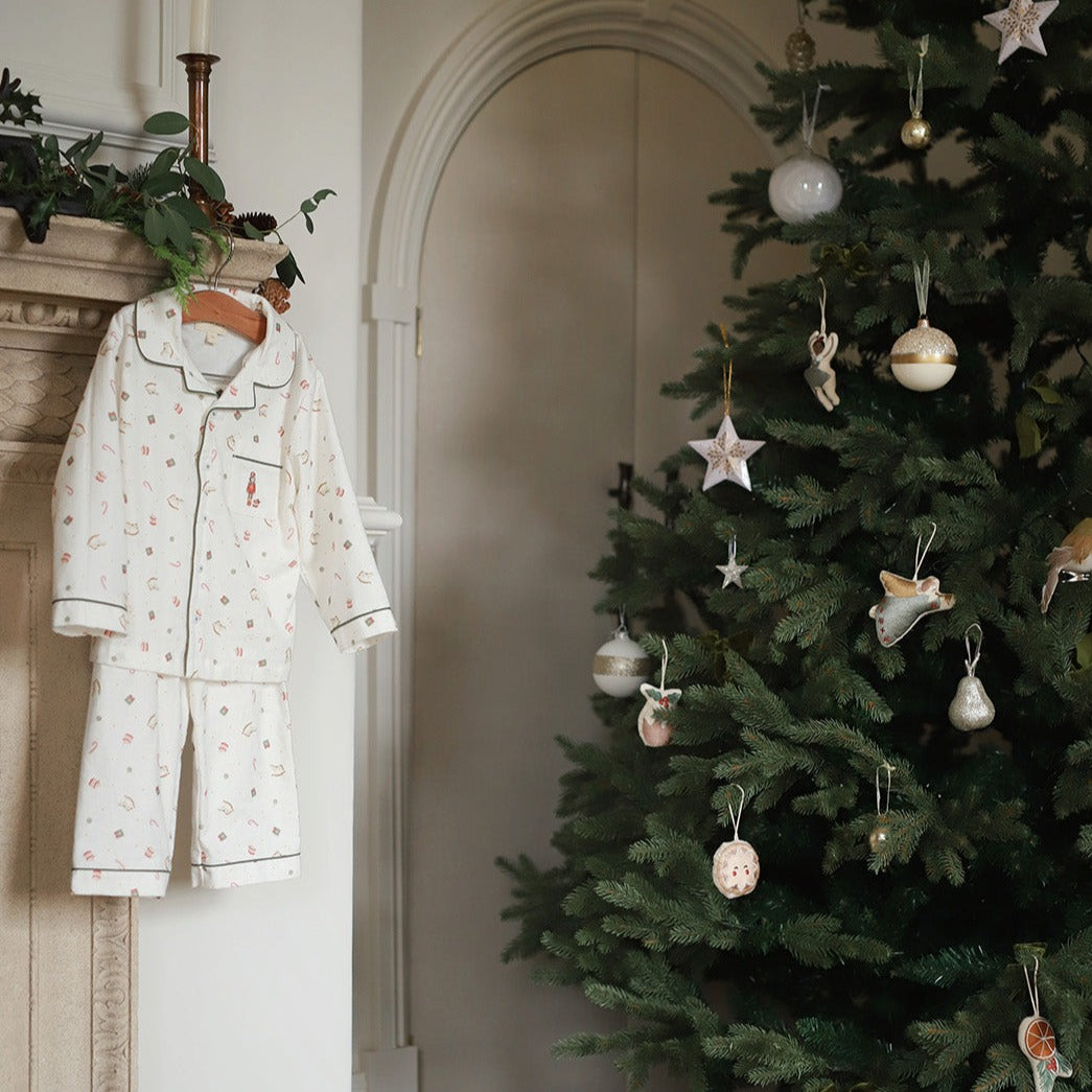 A boys pyjamas in nutrcker hanging next to Christmas tree