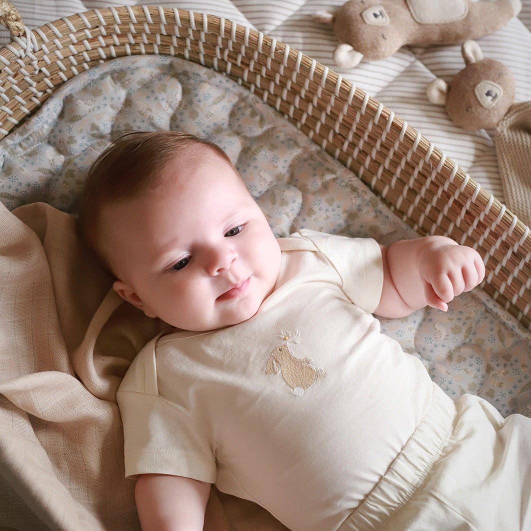 A baby lying on a cotton liner nature trail