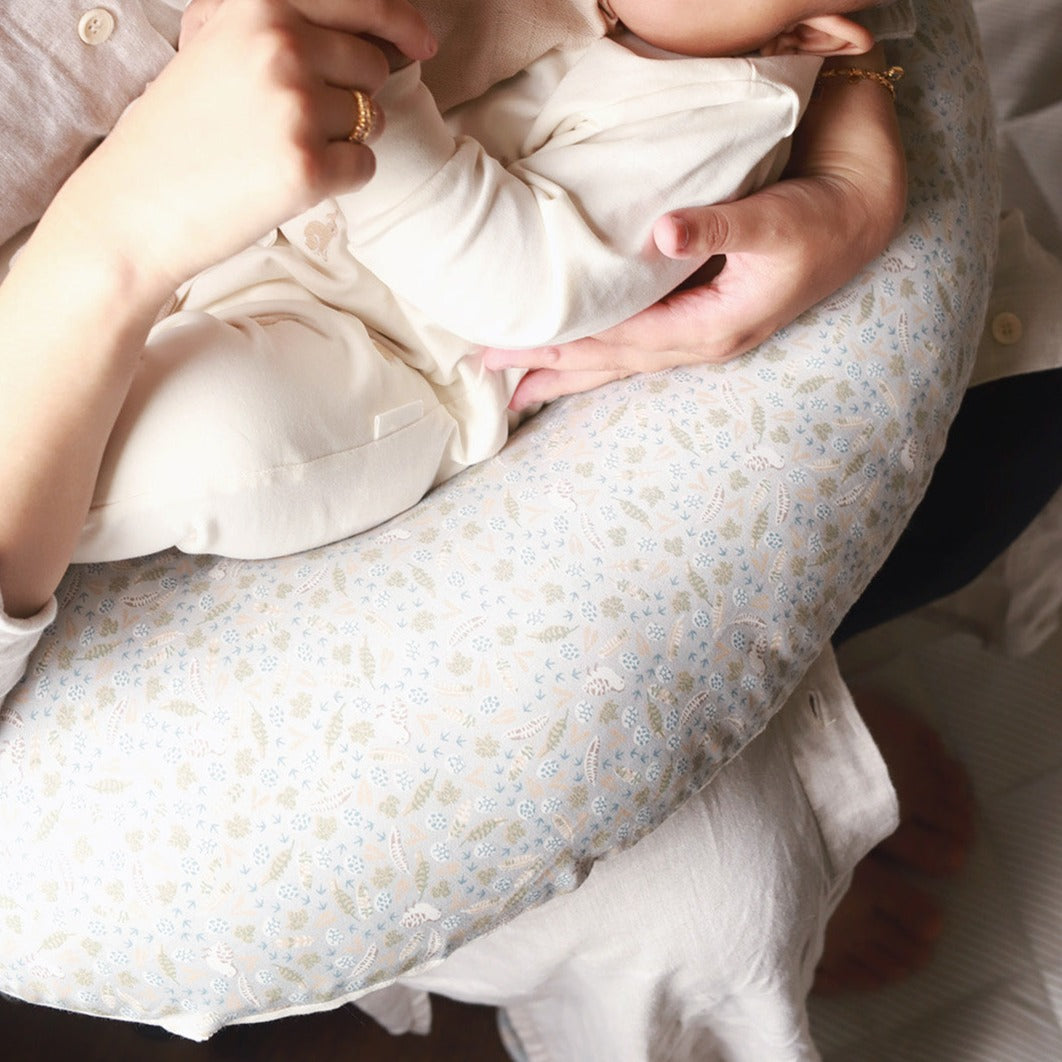 A baby lying on a nursing pillow nature trail