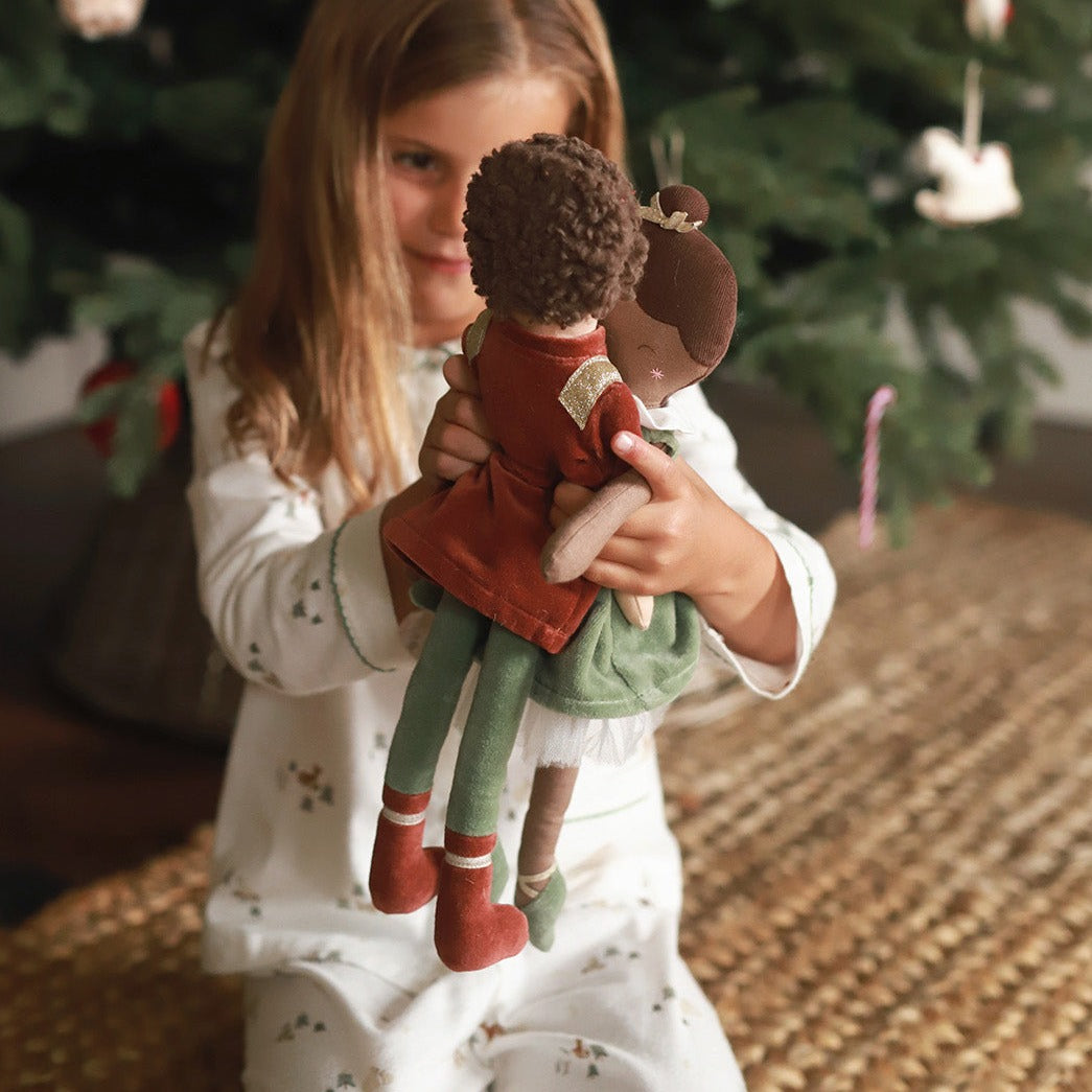 A girl playing with two Christmas dolls