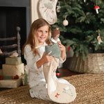 A girl putting the ballerina doll inside the dove Christmas stocking