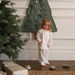 A girl wearing a nutcracker pyjamas standing next to the Christmas tree and advent calendar