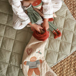 A kind putting the nutcracker dolls inside the Christmas stocking in gingerbread man design