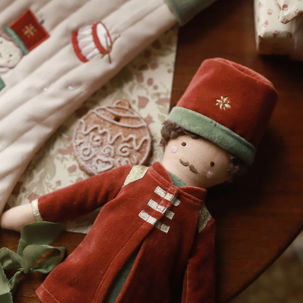A nutcracker doll lying next to the Christmas stocking