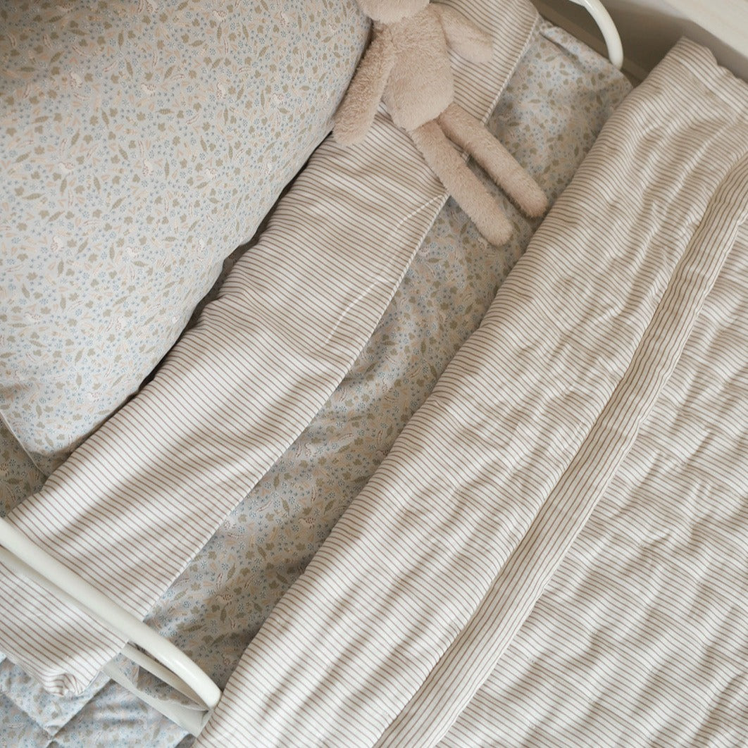 A quilted bedspread natural stripe on a bedding set