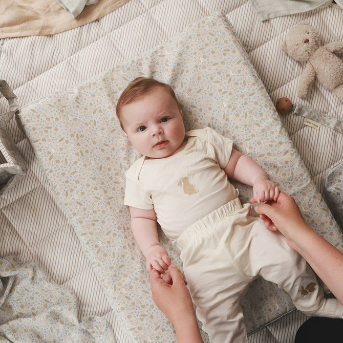 Aerial view of a baby lying on a changing cushion nature trail
