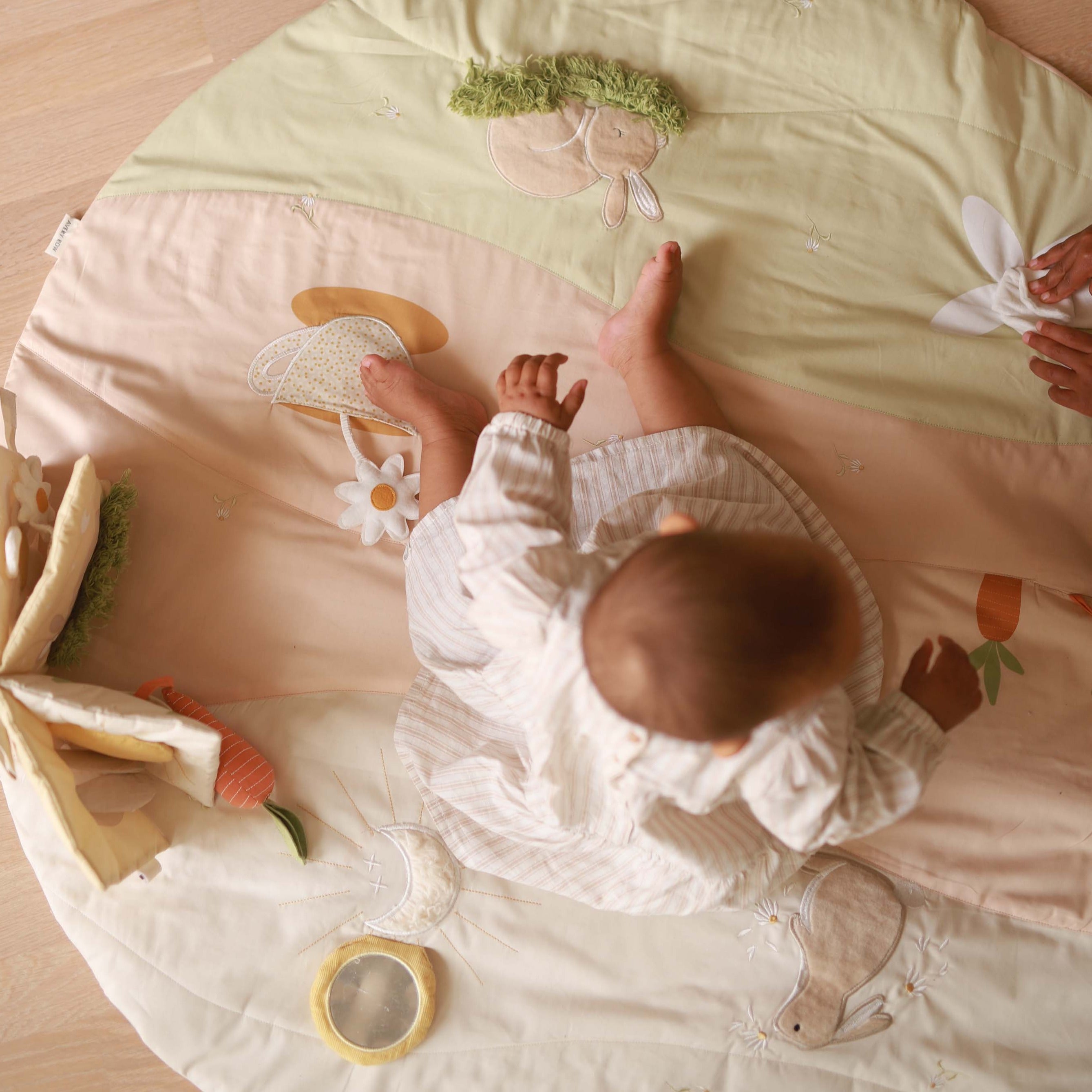 A baby playing on activity mat chamomile