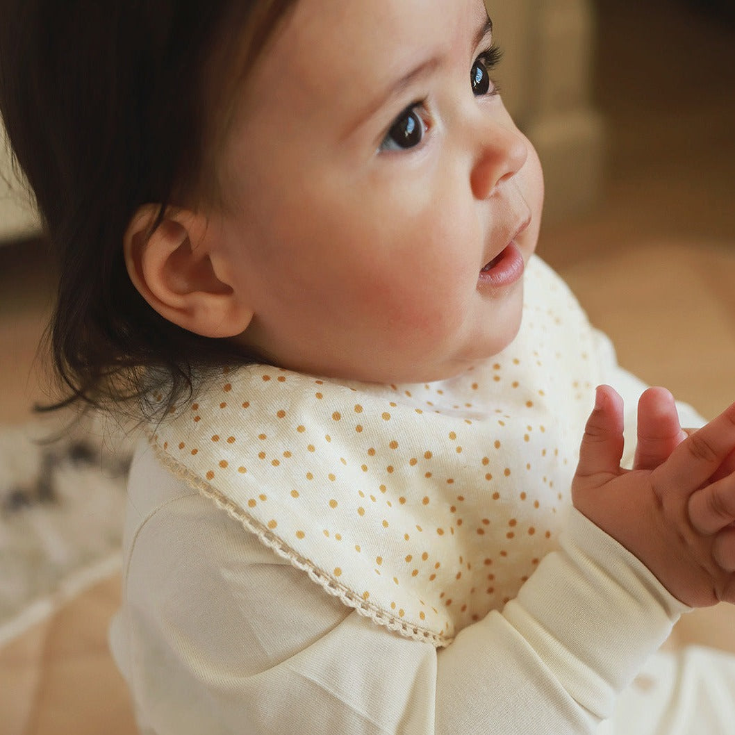 Baby wearing the bib in Daisy Meadow print