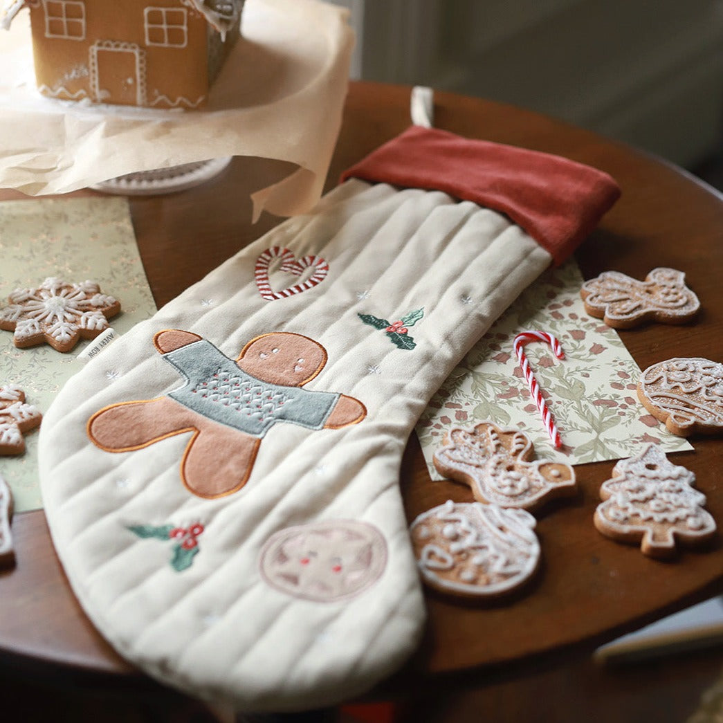 Christmas Stocking Gingerbread Man on top of a table with gingerbread and cookies