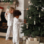 Girls on pyjamas winter ski are decorating the Christmas tree