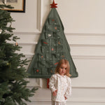 A kid standing next to advent calendar Christmas Tree