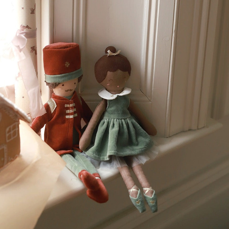 Nutcracker doll sitting beside a ballerina doll