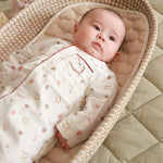 Sleepsuit nutcracker worn by a baby lying on changing basket
