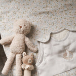 Teddy bear and other toys on top of a cotbed fitted sheet