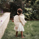 canvas wings and velvet flower fairy dress up worn by a girl playing with bubbles in a garden