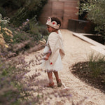 canvas wings and velvet flower fairy dress up worn by a girl in a garden