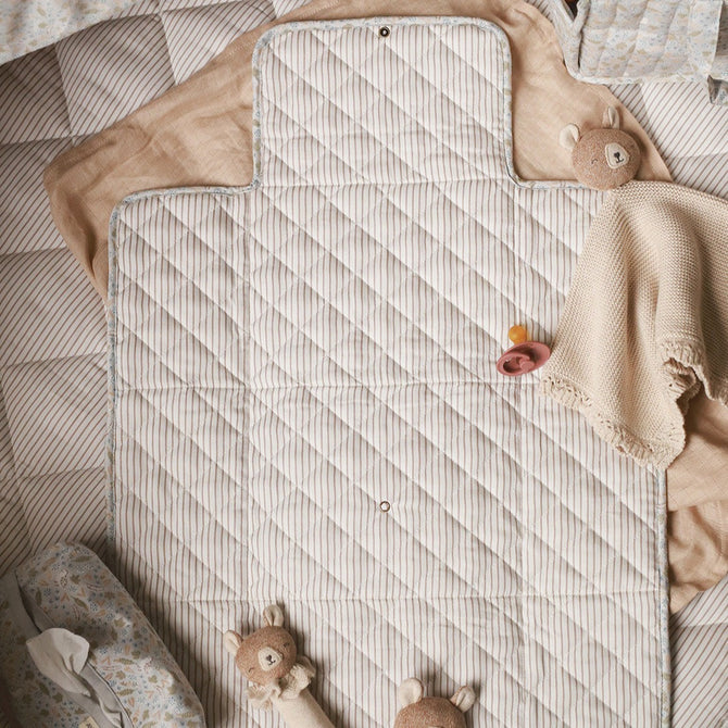 Teddies and baby wipes cover placed on top of travel changing mat nature trail