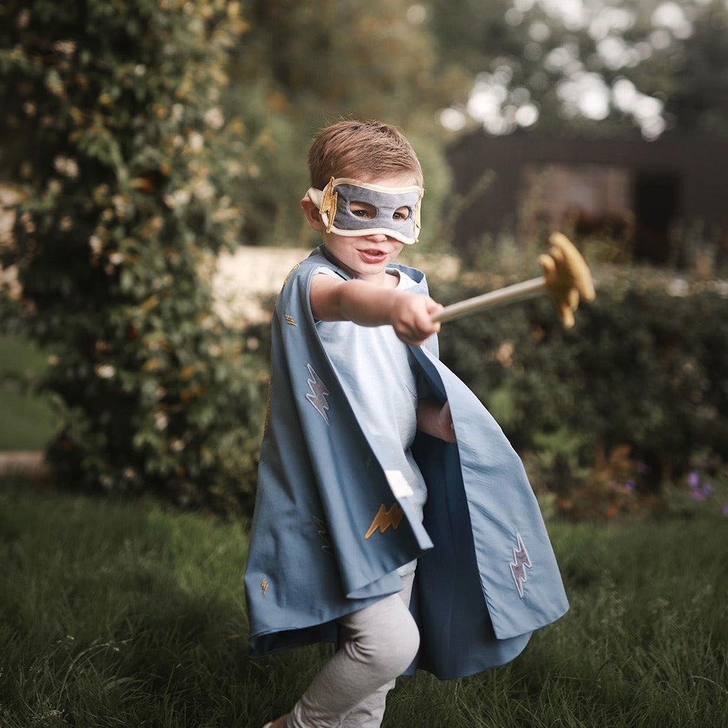 a boy playing superhero with lightning bolt wand