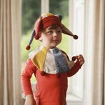red, yellow and blue ruff collar and crown worn by a boy as jester